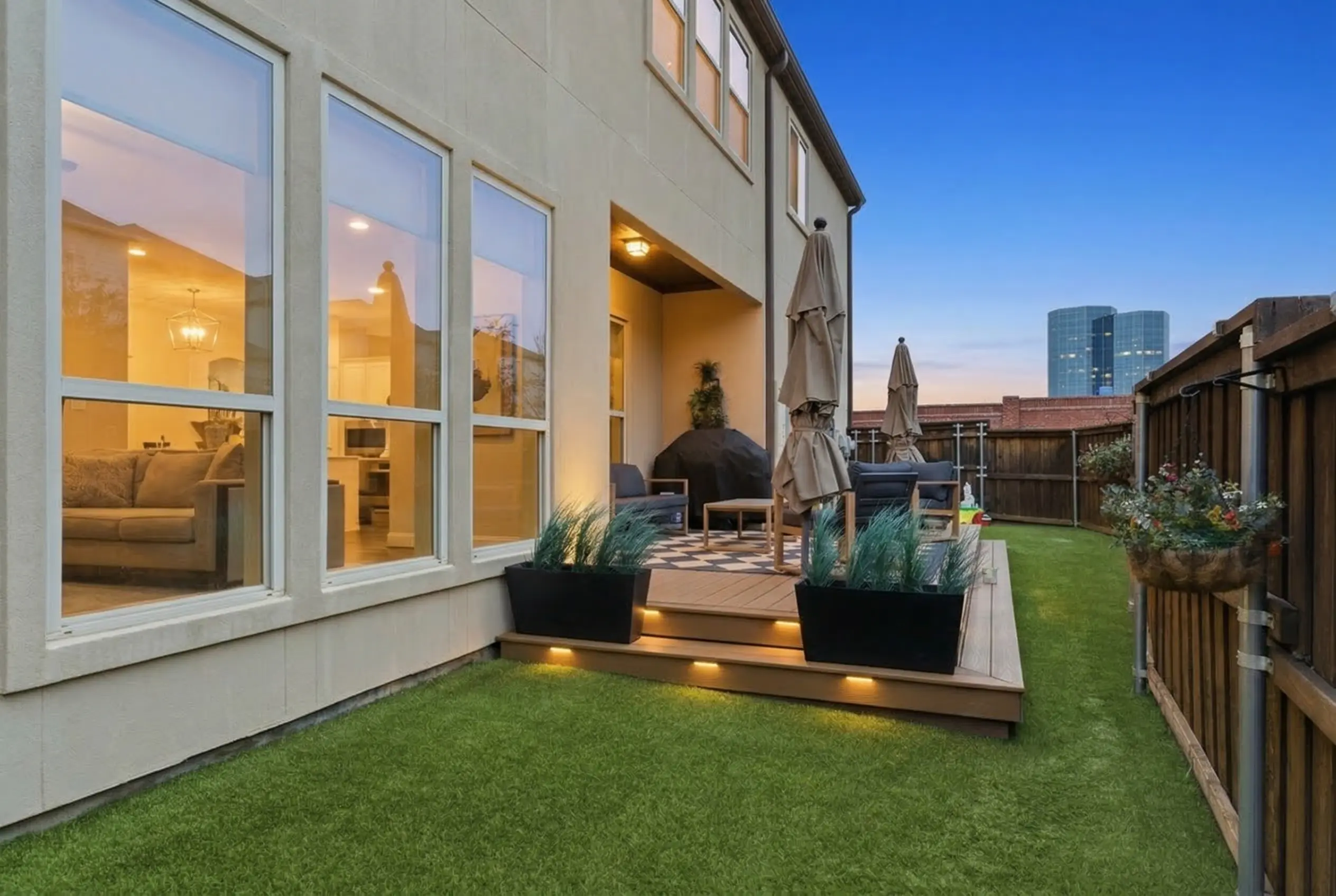 Backyard with turf lawn and deck at twilight