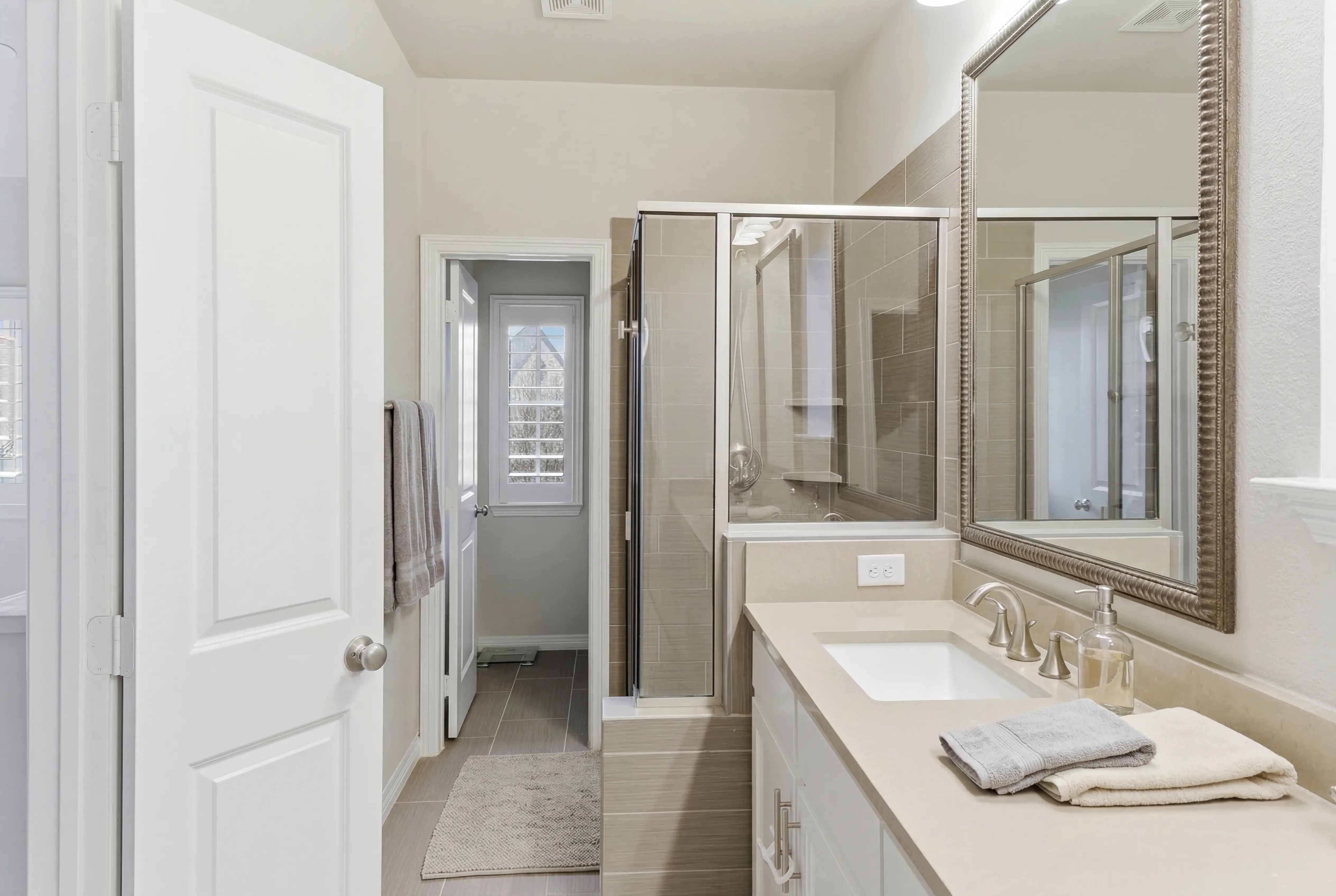 Primary bathroom with walk-in shower and framed mirror